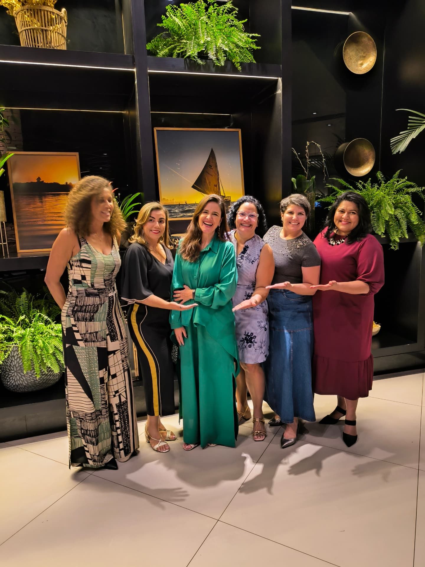 Seis mulheres sorrindo em pé durante encontro de mentoria