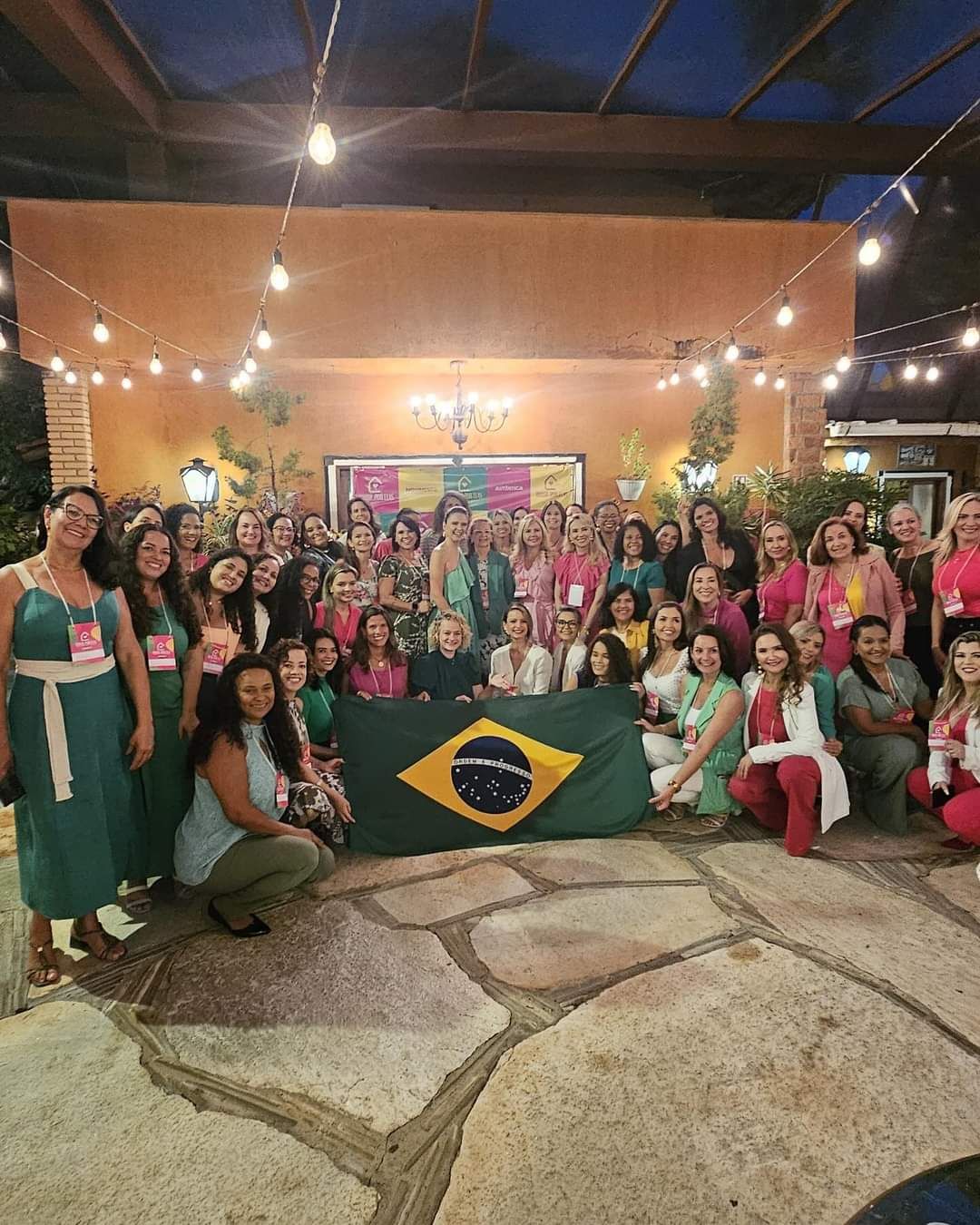Grande grupo de mulheres segurando a bandeira do Brasil no evento de lançamento
