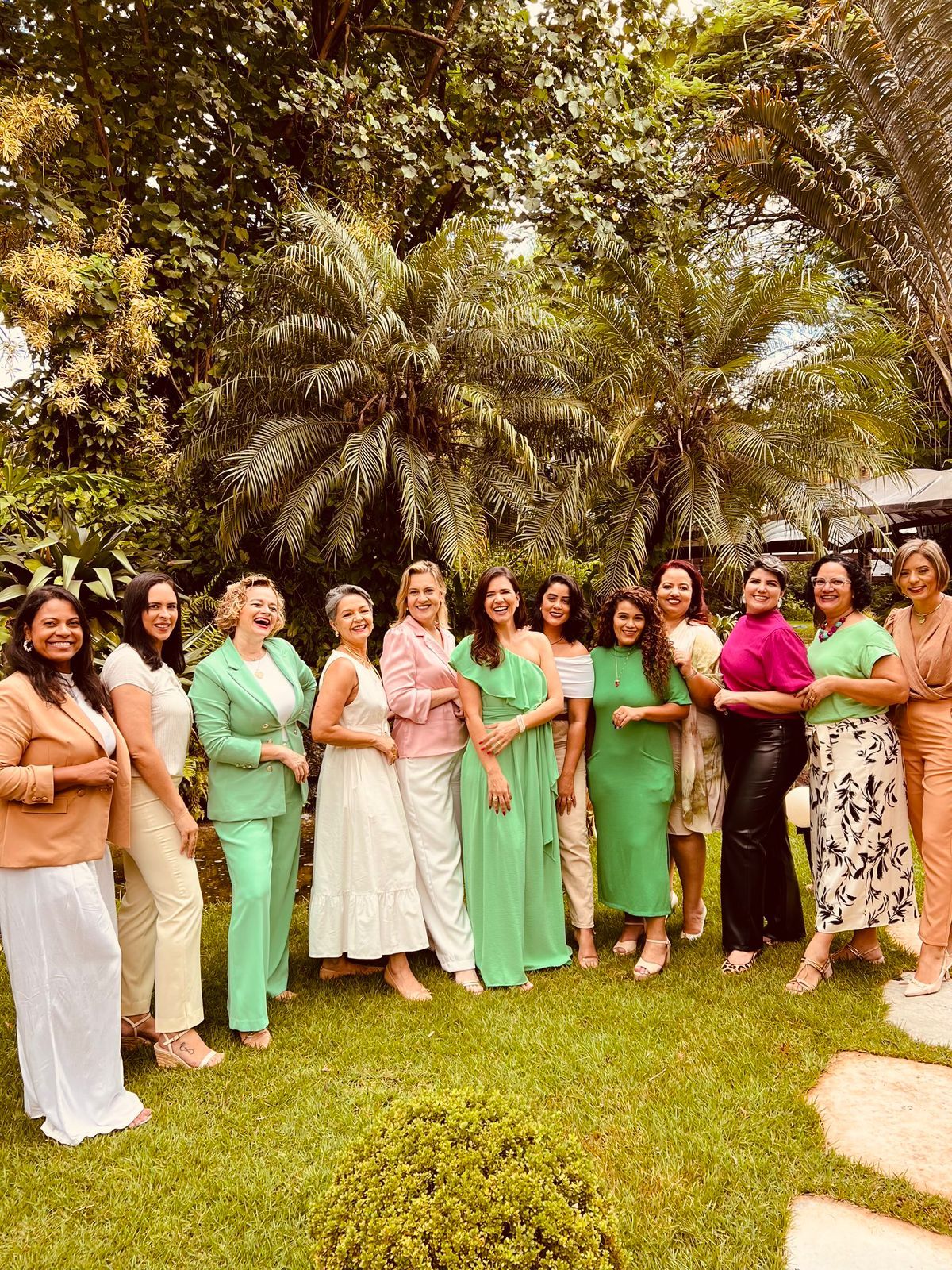 Grupo de empresárias posando em um jardim durante encontro da rede