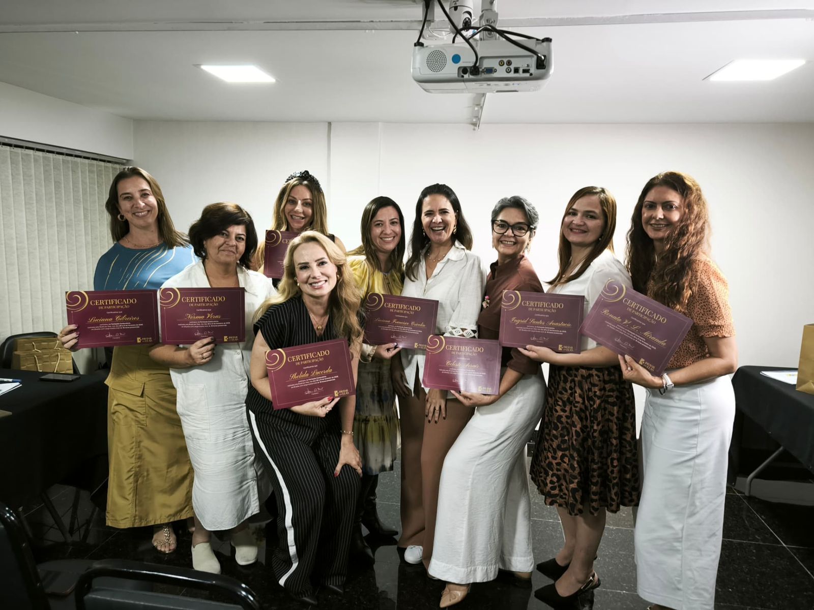 Grupo de mulheres exibindo certificados de participação da Brasil por Elas